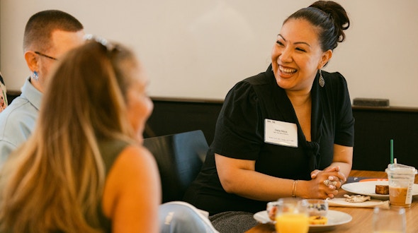 Woman speaking to two other people at a table