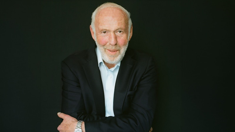 A photo of Jim Simons crossing his arms and smiling.