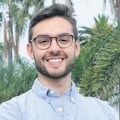 Maximiliano Isi standing in front of palm trees