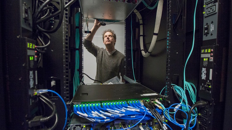 Ian fisk standing in the middle of a computer rack