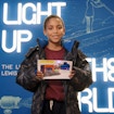A child visitor to Lewis Latimer House holds up a lighting project completed at the museum.