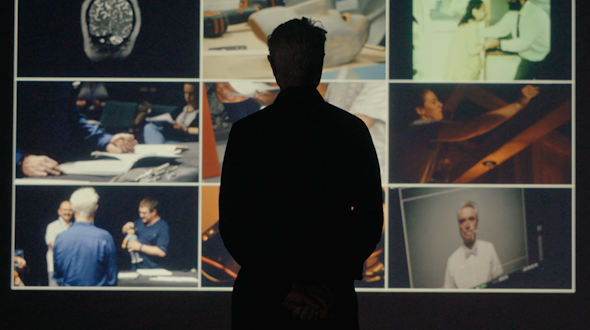 Man standing in front of a project screen of different videos