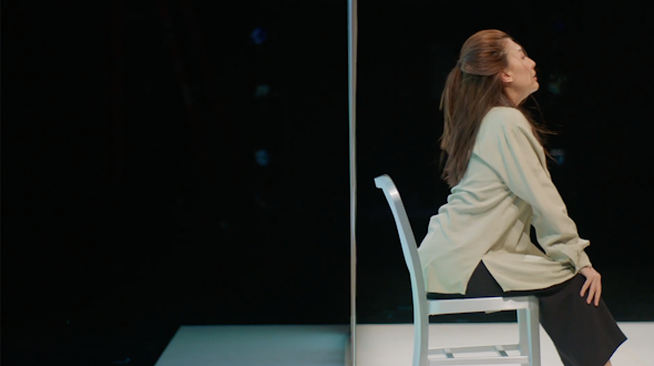 profile of a woman sitting on a metal chair