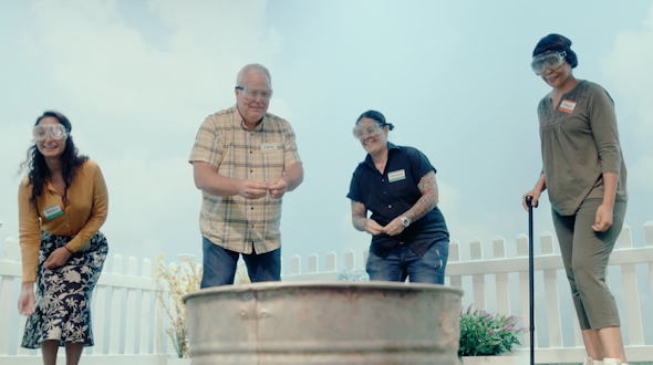 four people with goggles in front of a bin